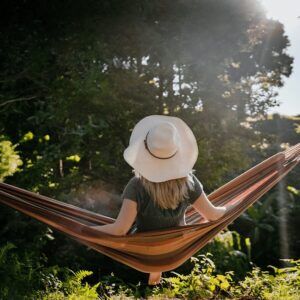 Frau genießt die Sonne in einer Hängematte. Wie ausgeprägt ist ihr Lebensmotiv Ruhe?